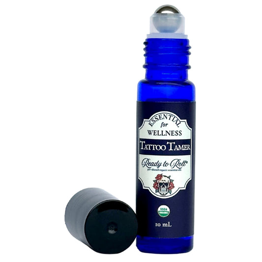 Tattoo Tamer by Ready to Roll® – natural tattoo aftercare with tea tree, lavender, frankincense, and coconut oil in a cobalt blue roller bottle by Essential for Wellness